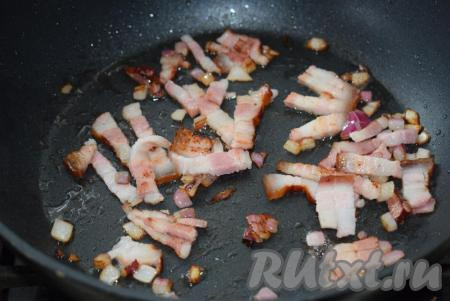 В сковороде разогреваем масло и кладем лук с беконом. Обжариваем лук с беконом до золотистости, иногда помешивая.