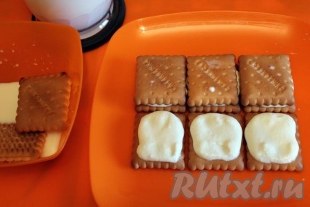 6 печенюшек окуните в молоко и выложите в 2 ряда по 3 штуки на плоскую поверхность. Поверх каждого печенья выложите по 1 столовой ложке творожного крема.