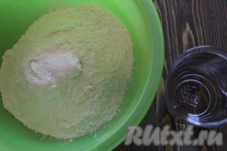 Просеять в глубокую миску муку, добавить соль. Постепенно вливать в муку воду и перемешивать тесто. 