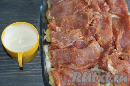 Затем выложить кусочки замаринованной свинины. Соединить майонез со сметаной и хорошо перемешать.