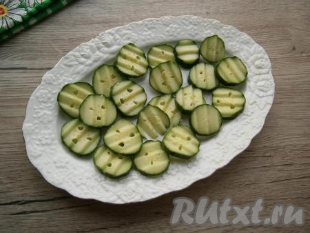 Все овощи вымыть, репчатый лук очистить от шелухи и тоже вымыть. На овальное блюдо нарезать свежие огурцы кружками&nbsp;средней толщины&nbsp;в один слой.