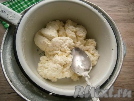 Отцедить творог от сыворотки через дуршлаг.