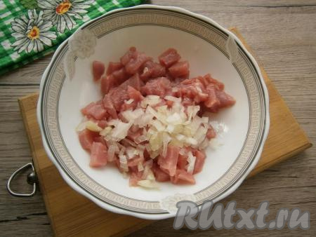 Свинину мелко нарезать или порубить топориком, добавить очищенный и мелко нарезанный репчатый лук.
