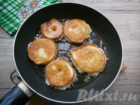 Жарить яблоки в кляре на небольшом огне до румяности с двух сторон.