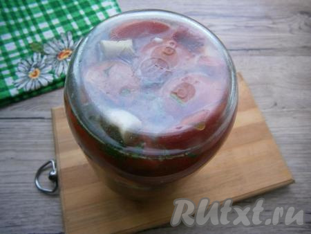 Накрыть банку прокипяченной крышкой и поместить в кастрюлю с горячей водой, на дно которой нужно поместить тряпочку. Довести воду до кипения на среднем огне и стерилизовать банку с помидорами 15 минут с момента закипания воды. Банку закатать, перевернуть и хорошо укутать. Оставить помидоры в таком положении до полного остывания.