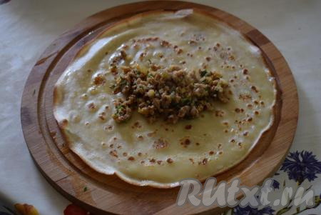 Готовую начинку охлаждаем до теплого состояния и приступаем к фаршировке блинов.&nbsp;Для этого кладем в центр каждого блинчика, примерно, по 1 столовой ложке с горкой начинки.