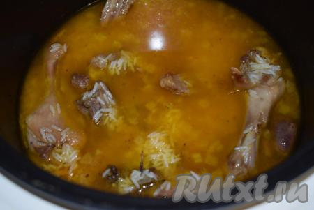 Далее берем наш замоченный рис, сливаем не впитавшуюся жидкость и выкладываем его в мультиварку к тушеной утке с овощами. Так как в процессе тушения утки крышку мультиварки мы не открывали, то жидкость, в которой она тушилась, практически совсем не испарялась и доливать воды более нам уже не надо. Распределяем рис равномерно при помощи ложки, пробуем, если надо, подсаливаем жидкость. Закрываем крышку мультиварки и еще раз выставляем ее на режим "Тушение" на 1 час.