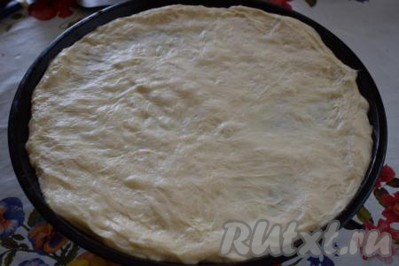 Готовое дрожжевое тесто слегка вымешиваем. Начинаем формировать луковый пирог, для этого форму для выпечки смазываем растительным маслом и выкладываем тесто на дно формы.&nbsp;Распределяем тесто руками по размеру формы (у меня форма диаметром 34 см).