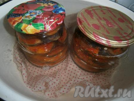 Накрыть банки прокипяченными крышками, поместить в кастрюлю, на дно которой выложить тряпочку. Влить горячую воду, чтобы она была до плечиков банок. Поставить кастрюлю с банками на огонь, довести воду до кипения. Стерилизовать банки с баклажанами 30 минут с момента закипания воды на среднем огне.
