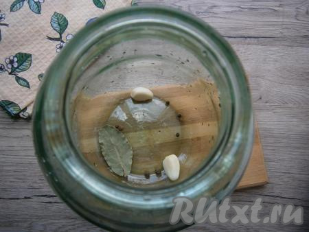 В чистую трехлитровую банку поместить лавровый лист, горошины чёрного и душистого перцев, 2 очищенных зубчика чеснока.