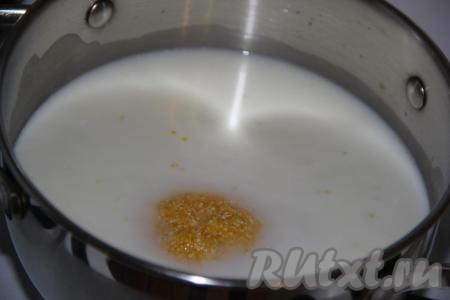 Воду соединить с молоком и влить в кастрюлю (для приготовления каши лучше взять толстостенную кастрюлю). Добавить промытую кукурузную крупу, перемешать, отправить на огонь и довести до кипения.