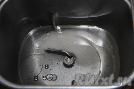 В ведёрко хлебопечки влить тёплую воду (не более 40 градусов). Добавить растительное масло и сахар.