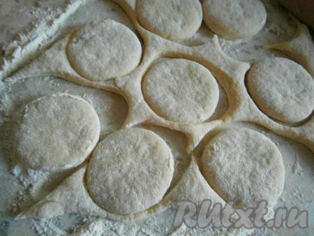 На столе, присыпанном мукой, одну часть теста раскатать в пласт толщиной около 1 см. Стаканом вырезать кружки.