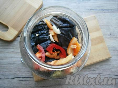 Банки простерилизовать. На дно каждой 1,5-литровой баночки влить по 50 мл уксуса, выложить немного чеснока и сладкого перца. Отваренные целые баклажаны выкладывать в банку (если баклажаны некрупные, то в "ряд" их может лечь по 3 штуки), чуть придавливая и пересыпая их сладким перцем и чесноком.