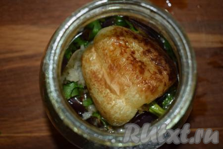 Выкладываем перцы на баклажаны в банку, посыпаем 1/3 частью чеснока&nbsp;и зелени, накрываем банку крышкой.
