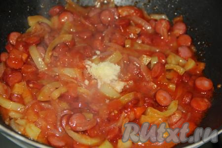 Очищенный чеснок, пропущенный через пресс, выложить на сковороду с овощами и колбасой, добавить&nbsp;соль и специи по вкусу, хорошо перемешать.