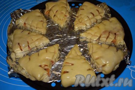 Подошедшие булочки с яблоками и корицей выкладываем на противень, застеленный пергаментом или фольгой, на некотором расстоянии друг от друга, смазываем яйцом и отправляем в разогретую духовку, выпекаем при температуре 180 градусов 25-30 минут.