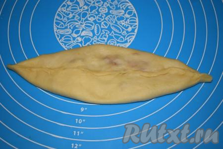 Сверху слегка прижимаем, а затем немного вытягиваем нашу булочку с яблоками и корицей в длину.