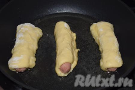 В сковороде разогреваем растительное масло, уменьшаем огонь и обжариваем сосиски в тесте в масле со всех сторон, примерно, 10 минут.