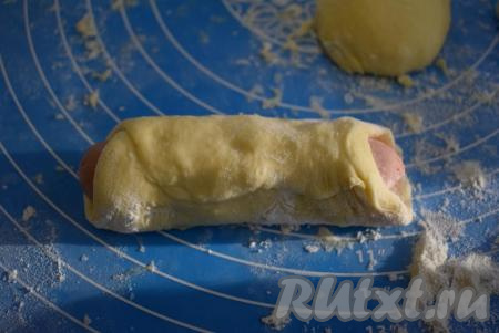 Сосиску заворачиваем в тесто, скрепляя края (как на фото). Аналогично формируем все сосиски в тесте.