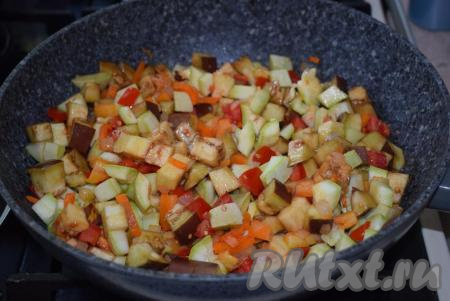 Перемешаем, накроем крышкой и потушим все вместе 7-8 минут, иногда перемешивая. Добавим к овощам баклажаны и кабачки, перемешаем.