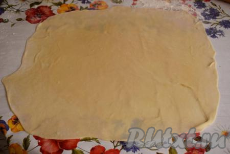 Берем одну часть теста и,&nbsp;присыпая стол мукой, раскатываем тоненько в пласт. Смазываем центр теста растительным маслом.
