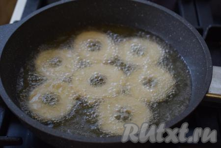 Сделаем огонь умеренным, чтобы во время жарки дрожжевые пончики хорошо прожарились внутри, а не просто подрумянились с краев.&nbsp;Выкладываем заготовки в сковороду и жарим по 7-8 минут.