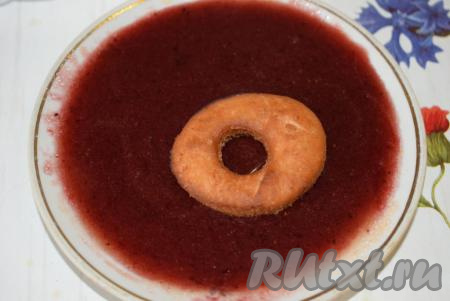 Окунаем немного остывшие пончики в сироп от варенья одной стороной и выкладываем на блюдо.