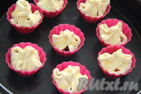 Смазать верх пирожков взбитым яйцом. Поставить противень в разогретую духовку и выпекать при температуре 180 градусов, примерно, 25-30 минут. Верх пирожков станет золотистого&nbsp;цвета.