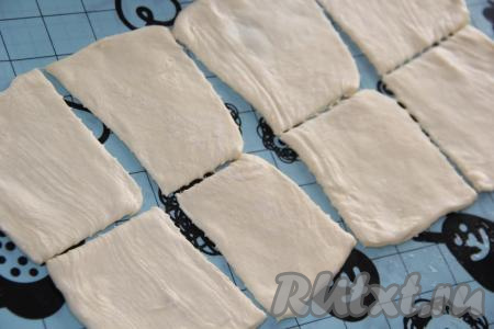 Слоёное тесто разморозить при комнатной температуре. Затем разрезать тесто на квадратики, у меня из 2 кусков теста получилось 16 квадратиков (будущих пирожков).