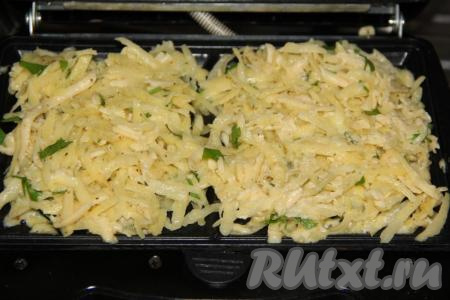 Вафельницу хорошо разогреть и смазать растительным маслом. Выложить по 2 столовые ложки&nbsp;картофельной массы на каждую сторону и равномерно распределить по поверхности.