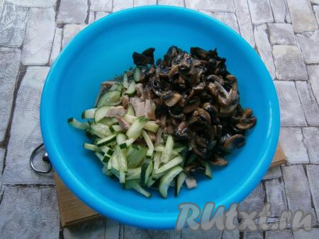 К нарезанному мясу добавить остывшие шампиньоны с луком, нарезанный брусочками огурец.