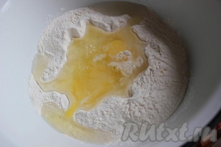 Для приготовления теста просейте муку, добавьте яйца и воду.