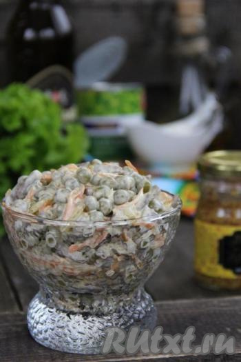 Подать вкусный салат с куриными сердечками и горошком к столу.