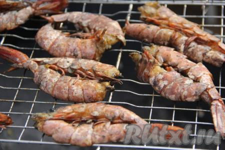Положить решётку на мангал, жарить лангустины по 2 минуты с каждой стороны.