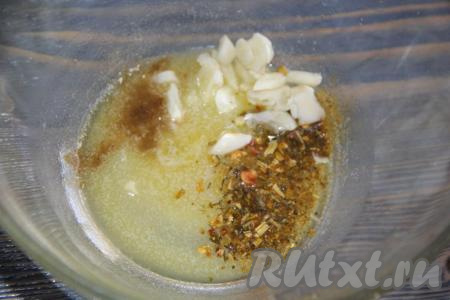 Для приготовления маринада соединить растопленное не горячее сливочное масло, специи для рыбы, чёрный молотый перец и очищенный чеснок, нарезанный на тонкие пластины.