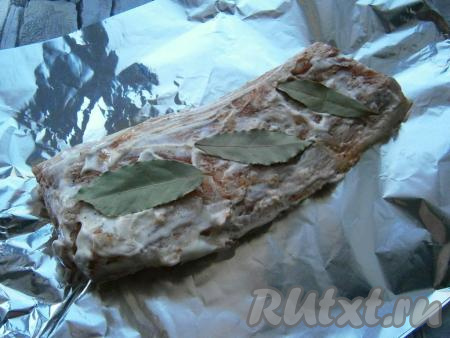 Смазать пузанину со всех сторон приготовленным соусом и выложить её на сложенный вдвое кусок фольги. Поверх куска сала с мясом выложить лавровые листья.