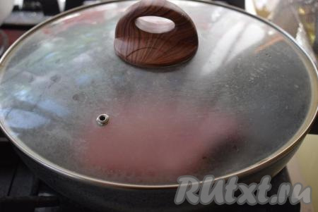 Накрыть сковороду крышкой и жарить свиные отбивные на косточке на среднем огне сначала с одной стороны, примерно, 5 минут. 