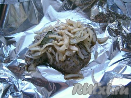 Далее лист фольги сложить вдвое, поместить на него кролика, сверху выложить лук из маринада. Полить мясо растительным маслом.