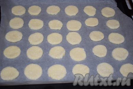 Подготовленное печенье сахарной стороной вверх выкладываем на противень, застеленный пергаментной бумагой.