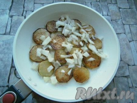 Обжарив последнюю порцию баклажанов, добавить к ним в сковороду очищенный и нарезанный произвольно репчатый лук. Обжарить на небольшом огне до прозрачности лука.