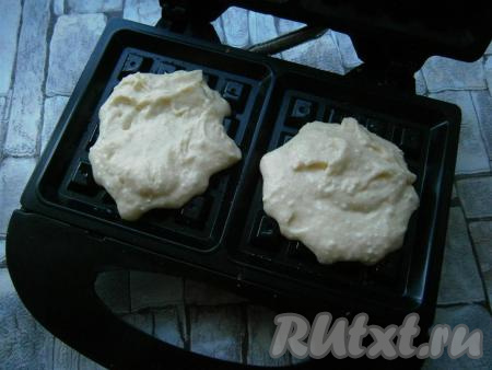 Форму для вафель смазать сливочным маслом, выкладывать в ячейки по 2-3 столовые ложки теста.