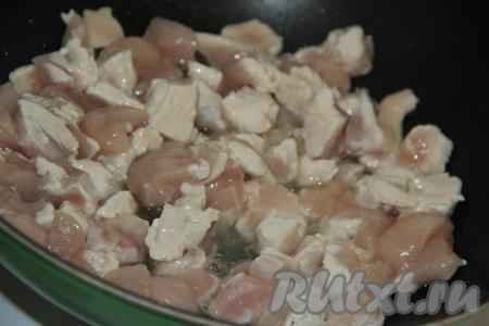 В сковороду налить немного растительного масла, выложить кусочки куриного&nbsp;филе и обжарить их в течение 5 минут на сильном огне, периодически помешивая.