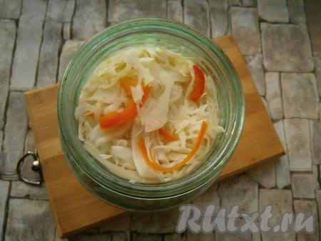 Накрыть кастрюлю крышкой и оставить капусту мариноваться на 2 часа при комнатной температуре. После этого капусту слегка отжать от маринада, поместить в стеклянную банку.