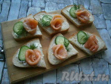 Рядом с рыбкой выложить по кружочку свежего огурца и украсить небольшой веточкой зеленого укропа.