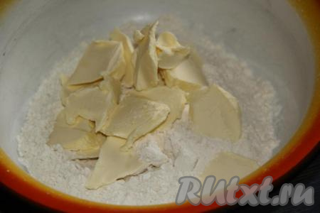 В миску всыпать муку, соль и сахар, добавить холодное масло, нарезанное на кусочки.