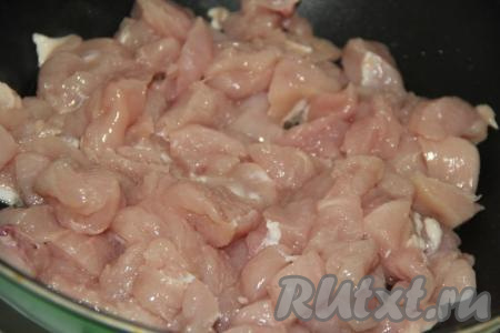 В сковороду с высокими бортиками влить немного растительного масла и выложить куриное филе, нарезанное на кусочки среднего размера.