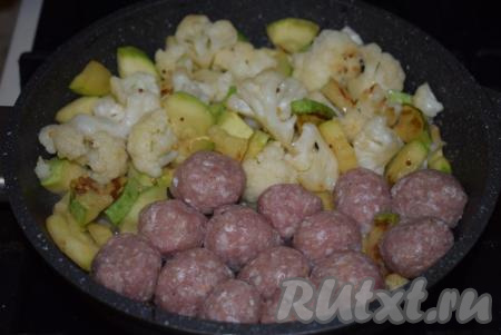 Сдвинем овощи на один край сковороды, а на освободившийся край выложим фрикадельки.