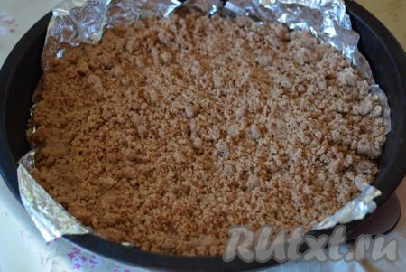 Дно формы диаметром 26 см застилаем пергаментом или фольгой (застилать дно формы надо обязательно, для того чтобы в дальнейшем можно было аккуратно извлечь пирог из формы). Такой пирог можно выпекать и в разъемной форме - это тоже очень удобно. На дно застеленной формы насыпаем чуть больше половины нашего теста.