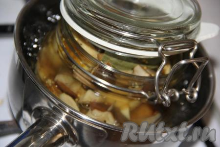 Взять кастрюлю или сотейник, на дно можно положить небольшую тряпочку. Налить в сотейник&nbsp;теплую воду и поставить туда&nbsp;банку с&nbsp;маринованными грибами ассорти. Вода должна доходить до "плечиков" банки. Поставить сотейник на огонь и стерилизовать 20 минут на&nbsp; среднем огне с момента закипания.